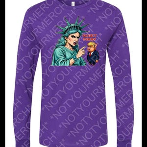 Peut inclure: T-shirt violet &agrave; manches longues avec un dessin de la Statue de la Libert&eacute; pointant vers un cochon en costume. Le texte "QUIET PIGGY" est au-dessus du cochon. Le t-shirt a un col rond et des manches longues.
