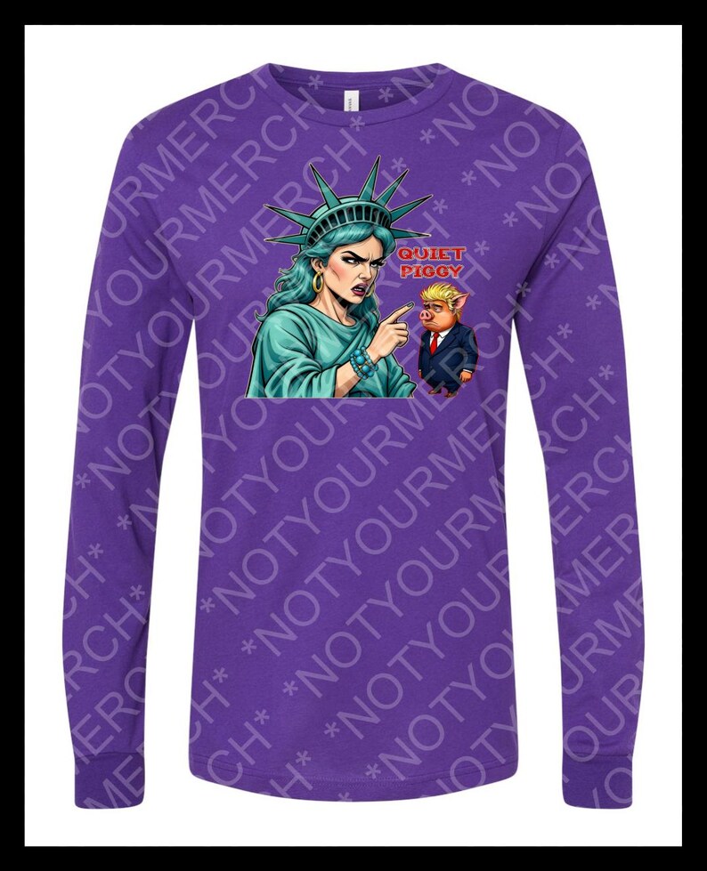 Peut inclure: T-shirt violet &agrave; manches longues avec un dessin de la Statue de la Libert&eacute; pointant vers un cochon en costume. Le texte "QUIET PIGGY" est au-dessus du cochon. Le t-shirt a un col rond et des manches longues.