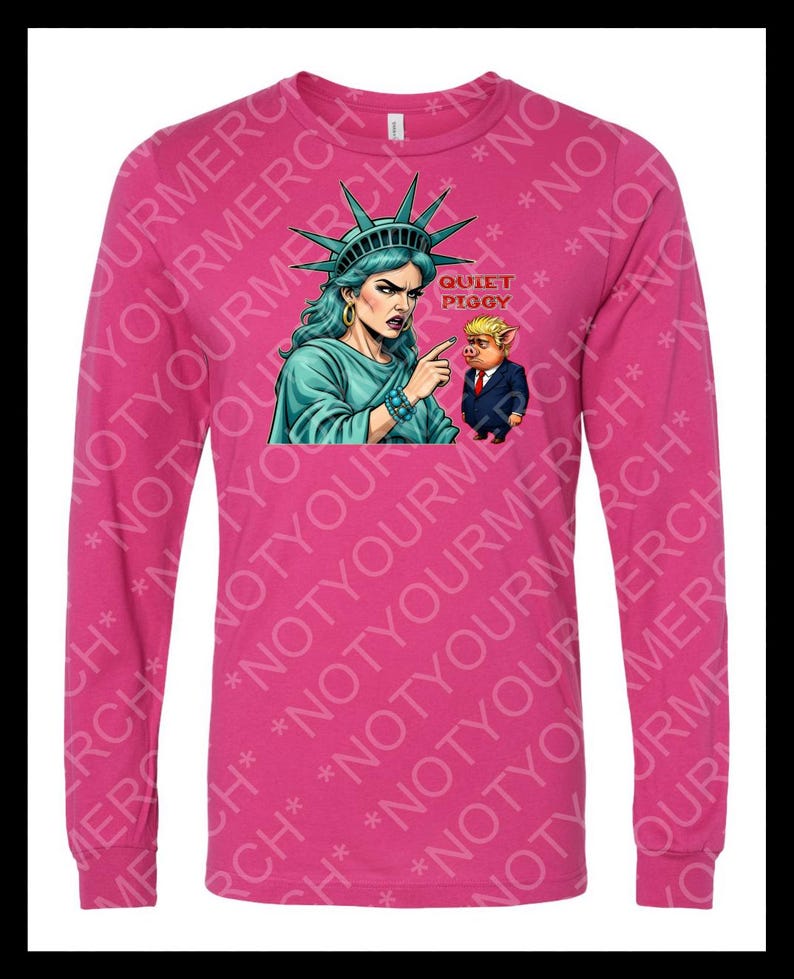 Peut inclure: Un t-shirt rose &agrave; manches longues avec un dessin de la Statue de la Libert&eacute; pointant vers un cochon en costume, avec le texte "QUIET PIGGY". La Statue de la Libert&eacute; est turquoise, et le cochon est en costume.