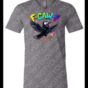 May include: Gray t-shirt featuring a cartoon crow with the text "F-CAW-F" in colorful graffiti-style lettering. The crow is black with its wings spread, and colorful paint splatters surround it.