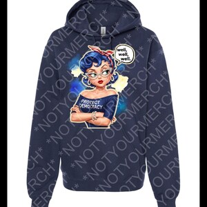 May include: A navy blue hoodie with a graphic of a woman with blue hair, glasses, and a red and white headband. The graphic includes the text "PROTECT DEMOCRACY" and a speech bubble saying "well, well, well."