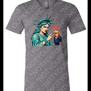 May include: Gray t-shirt featuring a graphic of the Statue of Liberty pointing at a pig in a suit, with the text "QUIET PIGGY". The Statue of Liberty is depicted with teal hair and a teal crown. The pig is wearing a red tie.