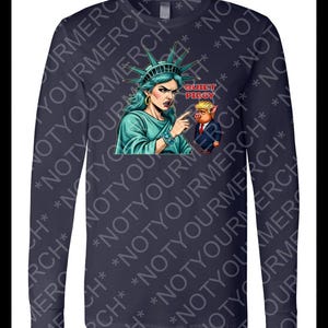Peut inclure: T-shirt &agrave; manches longues bleu marine avec un dessin de la Statue de la Libert&eacute; pointant vers un cochon en costume. Le texte "QUIET PIGGY" est au-dessus du cochon. Style confortable et d&eacute;contract&eacute;.