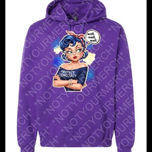 May include: A purple hoodie with a cartoon illustration of a woman with blue hair, glasses, and a red headband. The design includes the text "PROTECT DEMOCRACY" and a speech bubble saying "well, well, well." The hoodie has a drawstring hood.