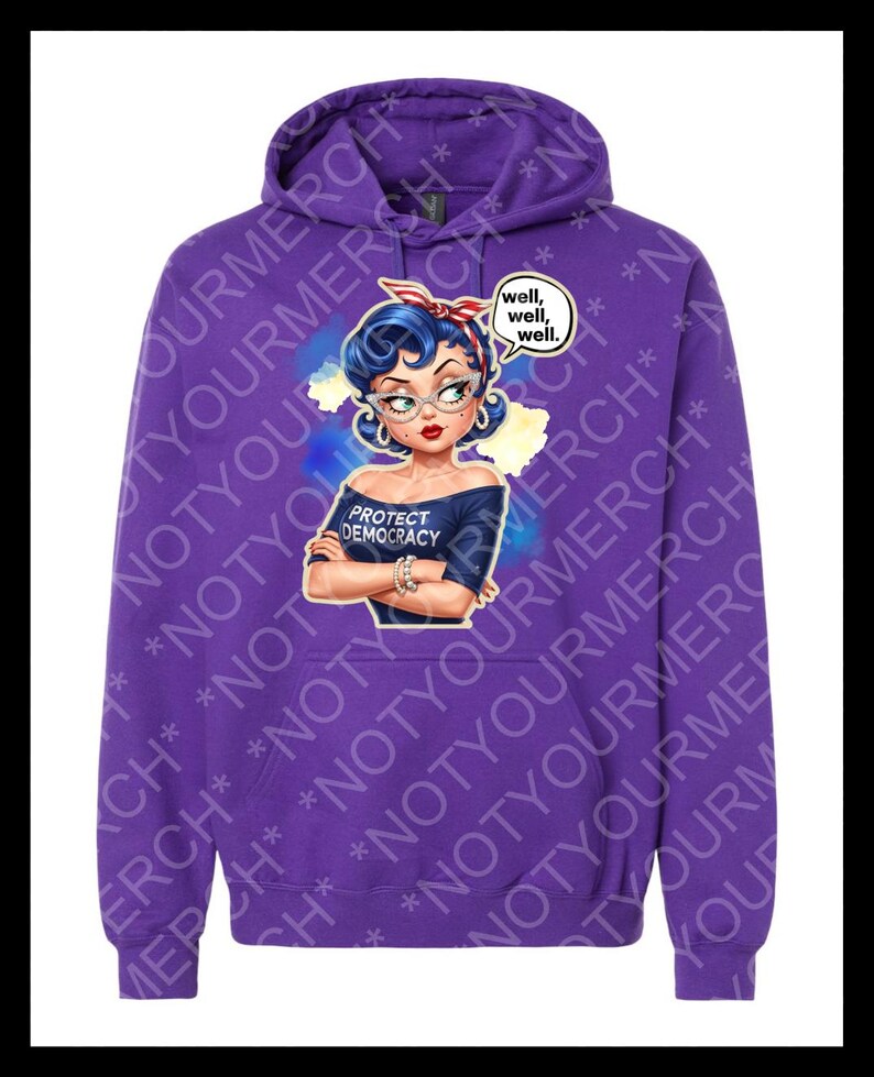 May include: A purple hoodie with a cartoon illustration of a woman with blue hair, glasses, and a red headband. The design includes the text "PROTECT DEMOCRACY" and a speech bubble saying "well, well, well." The hoodie has a drawstring hood.