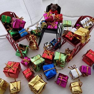 ドールハウスのミニチュア「そりのベルが鳴る」クリスマスプレゼントは、金属製のそりまたは引き車の中におもちゃを詰め込んでいます。