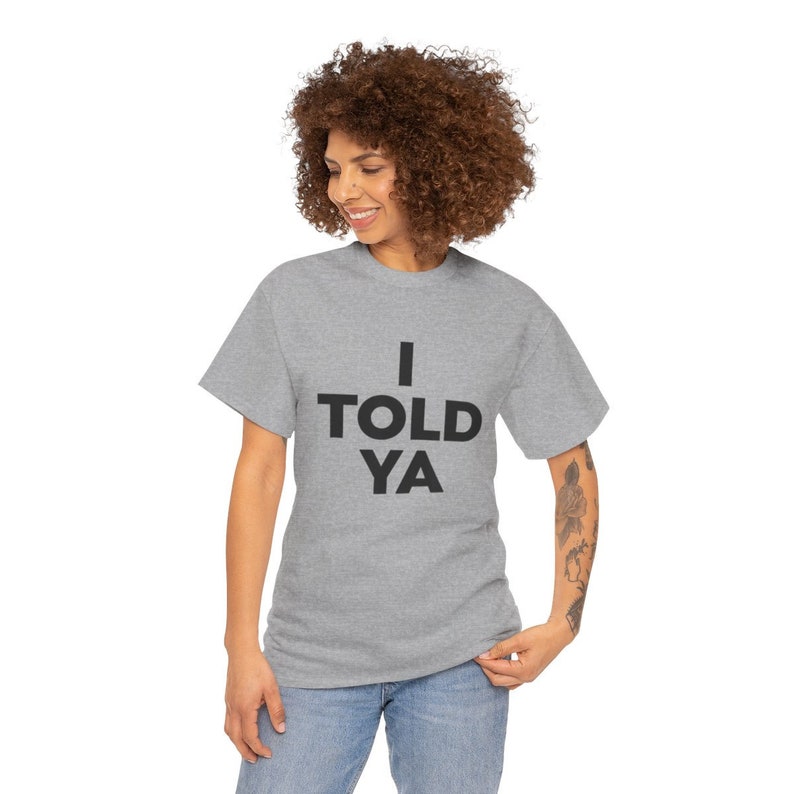 May include: A heather grey t-shirt with the text "I TOLD YA" printed in black.