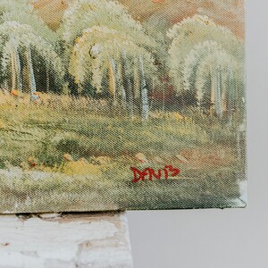 Op de afbeelding: Een schilderij van een boslandschap met een lichtgroen, geel en bruin kleurenschema. Het schilderij is rechtsonder getekend met "Davis".