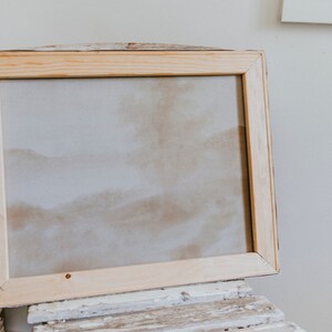 Op de afbeelding: Een blanco canvas in een natuurlijke houten lijst. De lijst is gemaakt van onbehandeld hout en heeft een eenvoudig ontwerp.