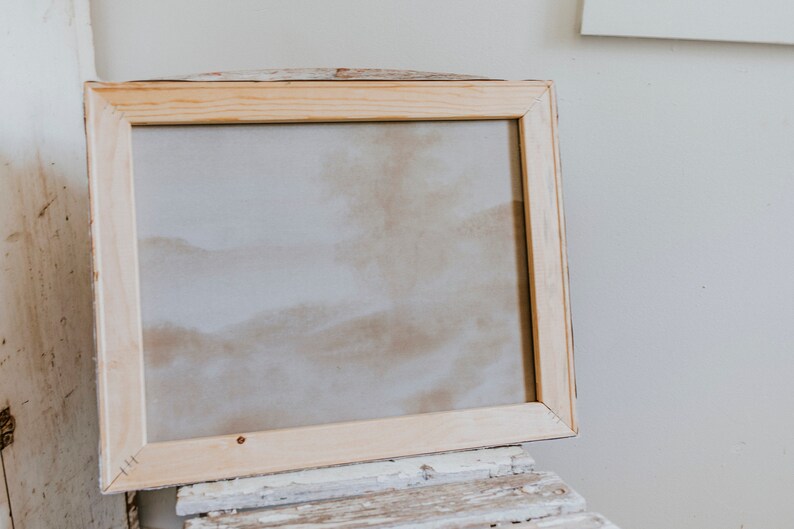Op de afbeelding: Een blanco canvas in een natuurlijke houten lijst. De lijst is gemaakt van onbehandeld hout en heeft een eenvoudig ontwerp.