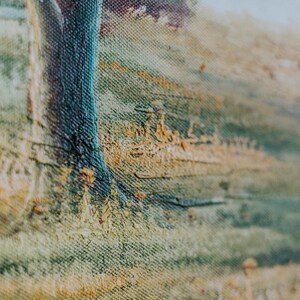 Op de afbeelding: Close-up van een textuurverf op canvas met een blauwe verticale streep en een achtergrond van gele, groene en bruine penseelstreken.
