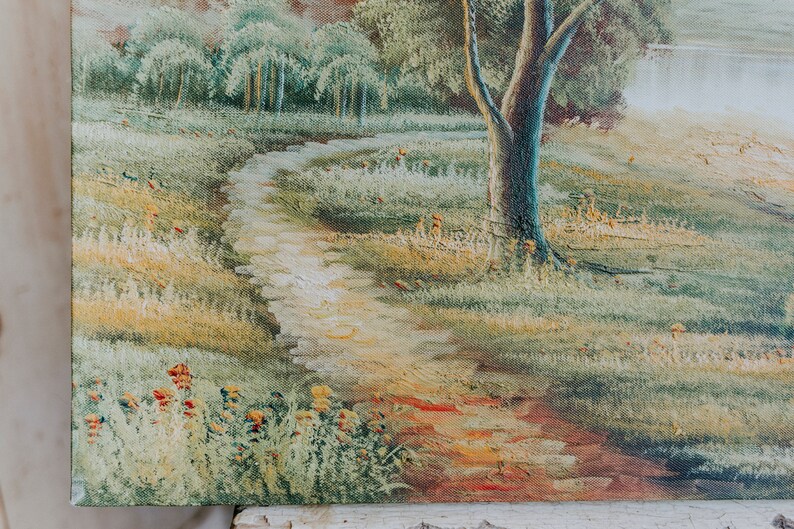 Op de afbeelding: Een schilderij van een kronkelend pad door een grasveld met een grote boom op de voorgrond. Het pad is lichtbruin en het veld is een mix van groen en geel. De boom heeft een dikke stam en takken die tot aan de hemel reiken. Het schilderij is in een realistische stijl geschilderd en heeft een warme, uitnodigende sfeer.