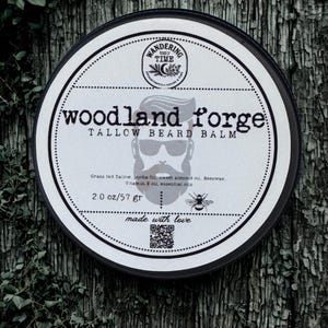 以下が含まれることがあります： 黒い縁と白いラベルが付いた、Woodland Forge Tallow Beard Balmの丸い缶。 ラベルにはテキストとあごひげを生やした男性のグラフィック、そして「Wandering Time」と「made with love」の文字が記載されています。 57グラム入り。