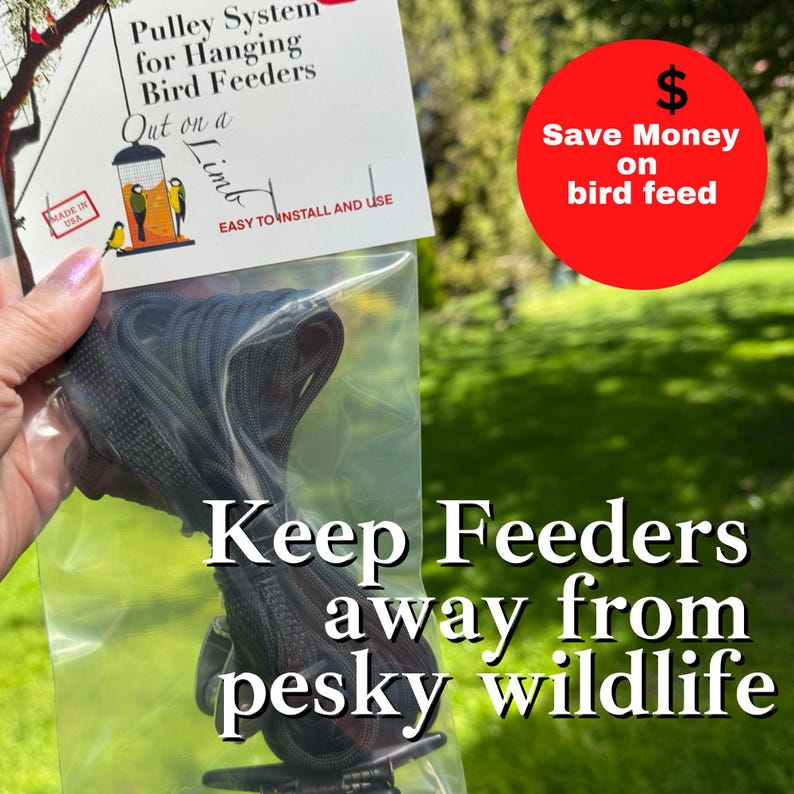 May include: A pulley system for hanging bird feeders packaged in a clear plastic bag with a white header card. The card features the text Pulley System for Hanging Bird Feeders, Out on a Limb, EASY TO INSTALL AND USE, and MADE IN USA.