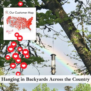 May include: A cylindrical metal bird feeder hangs from a tree branch against a rainbow background. An inset graphic shows a map of the United States titled Our Customer Map with red dots across the country and the text Hanging in Backyards Across the Country.