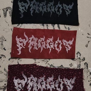 May include: Three rectangular patches featuring the word "PHAGGOV" in a gothic font. The patches are black, red, and maroon, with the text in white. These patches are likely designed for application on clothing or accessories.