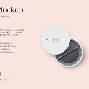 Puede incluir: Una maqueta de botón de pin blanco con un pin negro y un fondo gris. El botón tiene el texto "YOUR DESIGN here".