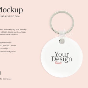 Puede incluir: Maqueta de llavero redondo blanco con un llavero plateado. El llavero tiene un diámetro de 5 cm y tiene el texto "Your Design here" impreso en él.