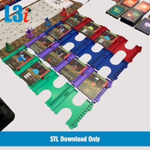 Può includere: Un set di porta carte da gioco in plastica di colore verde, viola, blu e rosso, disposti a griglia. Ogni supporto contiene una carta da gioco con illustrazioni e testo. Il set include piccole miniature di personaggi in plastica.