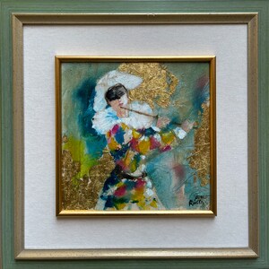May include: A framed painting of a masked figure in a colorful costume playing a flute. The background is a mix of blue, green, and gold.
