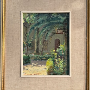 May include: A framed oil painting depicting a lush green garden with palm trees and a stone pathway leading to a doorway. The painting is signed "L. Cavallaro" in the lower right corner.