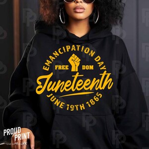 May include: Black hoodie with a yellow circle graphic that says "Emancipation Day" with a raised fist in the center and "Juneteenth" in a script font below. The text "Free Dom" is above the fist and "June 19th 1865" is below the script font.