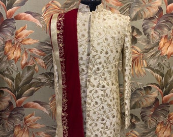 Könnte beinhalten: Eine cremefarbene bestickte Kurta mit einem maroonfarbenen Schal. Die Kurta hat ein Blumenmuster und der Schal hat einen goldenen Rand.