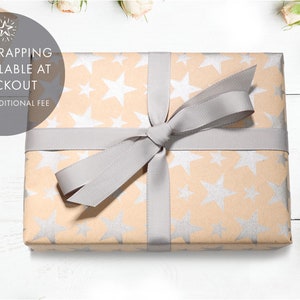 May include: A gift wrapped in brown paper with a silver star pattern. The gift is tied with a gray ribbon and bow. The text "Gift wrapping is available at checkout for an additional fee" is visible in the image.