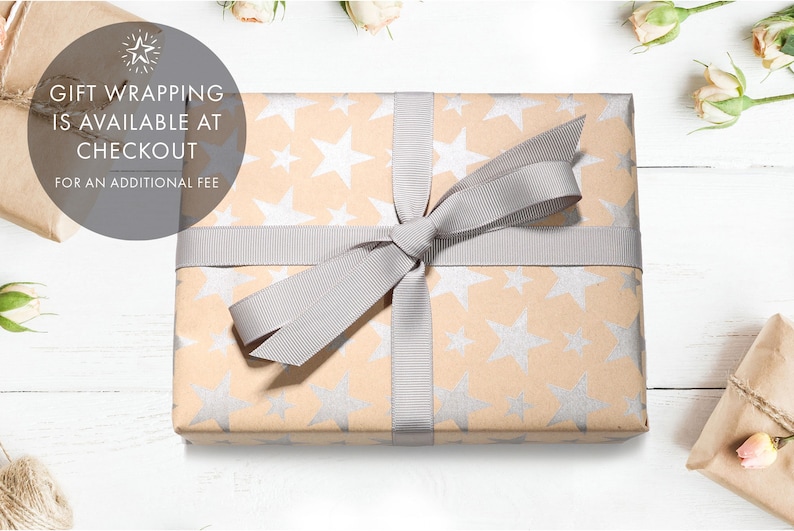 May include: A gift wrapped in brown paper with a silver star pattern. The gift is tied with a gray ribbon and bow. The text "Gift wrapping is available at checkout for an additional fee" is visible in the image.