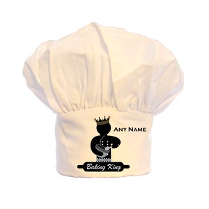 May include: White chef's hat featuring a black silhouette of a baker wearing a crown and holding a mixing bowl. The text "Baking King" and "ANY NAME" are printed on the hat.
