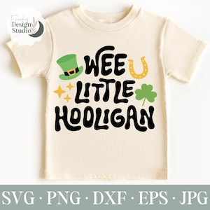 May include: A white t-shirt with a green leprechaun hat, gold horseshoe, shamrock, and the text "Wee Little Hooligan" in black.