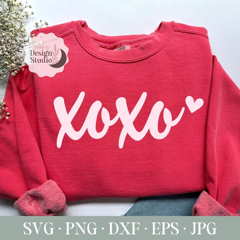 May include: A pink sweatshirt with the word "XOXO" in white script with a small pink heart.