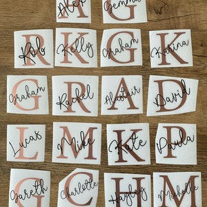 May include: A selection of personalized name decals. Each decal features a rose gold letter with a name in a cursive font. Names include Alex, Gemma, Rob, Kelly, Graham, Karina, Lucas, Mike, Kate, Paula, Gareth, Charlotte, Hayley, and Michelle.