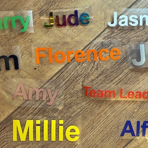 May include: A collection of colourful name tags with names like Harry, Jude, Jasmine, Sam, Florence, Jack, Amy, Team Leader, Millie, and Alfie.