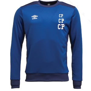 May include: A blue long-sleeved sweatshirt with a crew neck and navy blue accents on the shoulders, cuffs, and hem. The Umbro logo is on the chest, and the letters "CP" are stacked vertically on the right side.