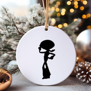 May include: White ceramic Christmas ornament with a black silhouette of a cartoon character with a large head and long legs.