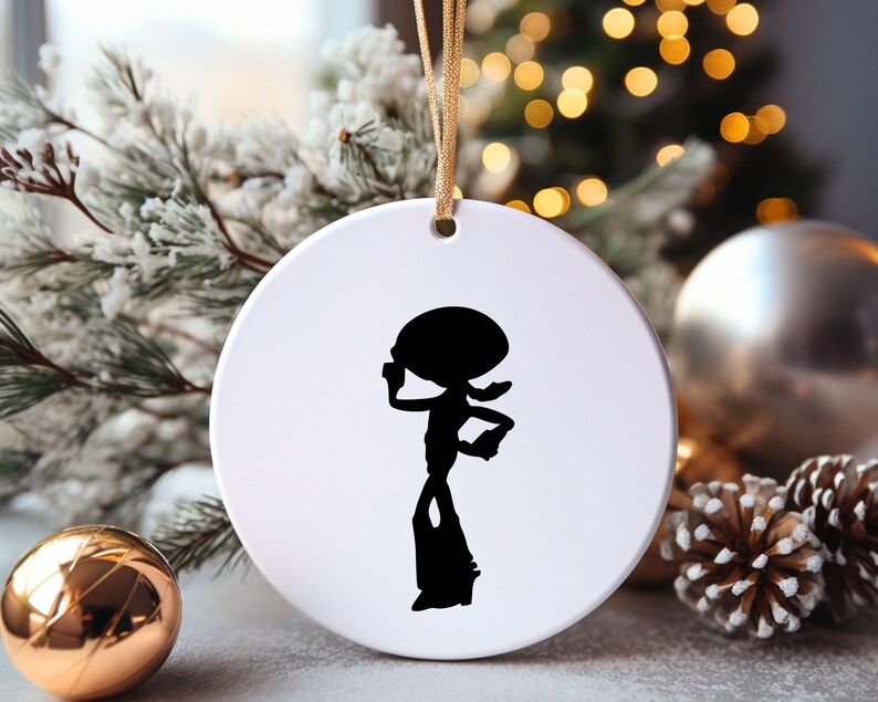 May include: White ceramic Christmas ornament with a black silhouette of a cartoon character with a large head and long legs.