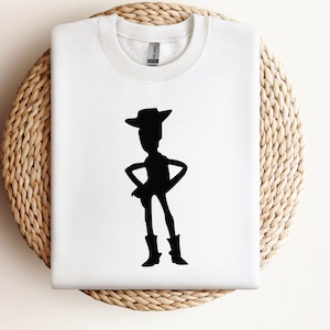 May include: White t-shirt with a black silhouette of Woody from Toy Story.