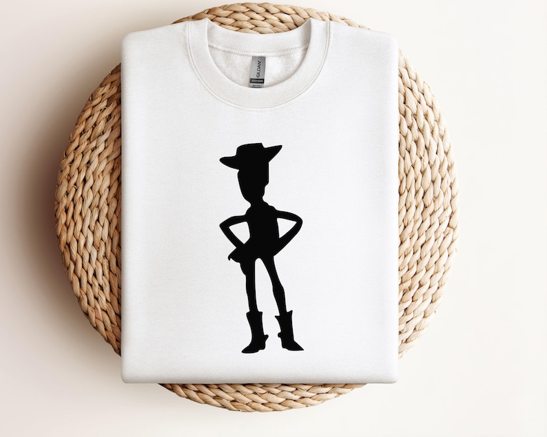 May include: White t-shirt with a black silhouette of Woody from Toy Story.