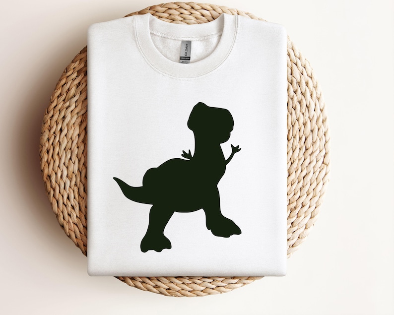 May include: White t-shirt with a black silhouette of a dinosaur.