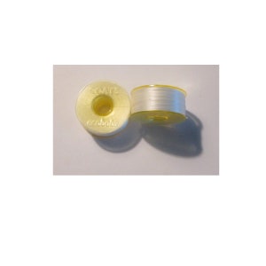 May include: Two spools of white thread, one with a yellow plastic bobbin labeled "COATS 600 Yards".