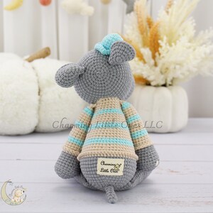 Handmade gray mouse plush toy with a striped blue and beige sweater, featuring soft yarn texture and an embroidered tag reading "Charming Little One."