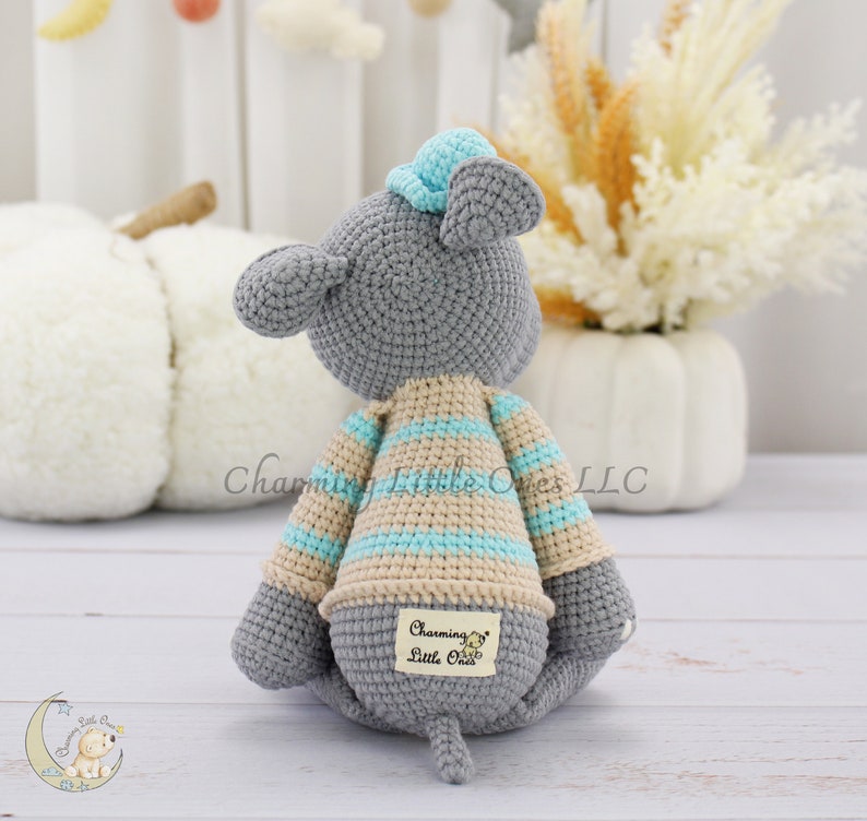 Handmade gray mouse plush toy with a striped blue and beige sweater, featuring soft yarn texture and an embroidered tag reading "Charming Little One."
