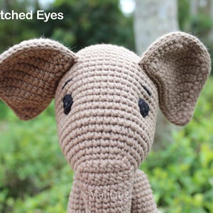 Handmade crochet mouse toy in soft beige tones, featuring large floppy ears, embroidered eyes, and a cheerful stitched smile.