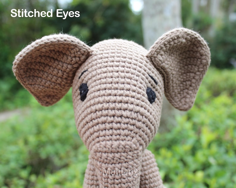 Handmade crochet mouse toy in soft beige tones, featuring large floppy ears, embroidered eyes, and a cheerful stitched smile.