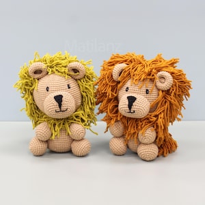 May include: Two crocheted lion stuffed animals. One lion has a yellow mane, the other has an orange mane. Both have tan faces, black noses, and small, round ears. The lions are sitting upright, with their paws in front.