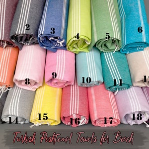 May include: A collection of 19 Turkish Peshtemal towels in various colors, rolled up and arranged in rows. The towels are made of cotton and have a striped pattern. The text "Turkish Peshtemal Towels for Beach" is printed at the bottom of the image.
