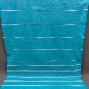 May include: A turquoise and white striped beach towel with white fringe. The towel is made of cotton and is soft and absorbent.