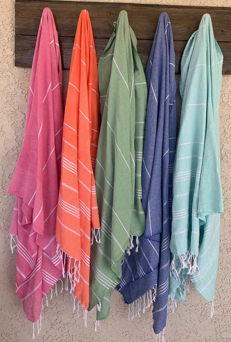 May include: Five striped towels hanging on hooks. The towels are in various colors, including pink, orange, green, blue, and light blue.