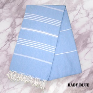 May include: A light blue Turkish towel with white stripes. The towel has fringe on the ends.